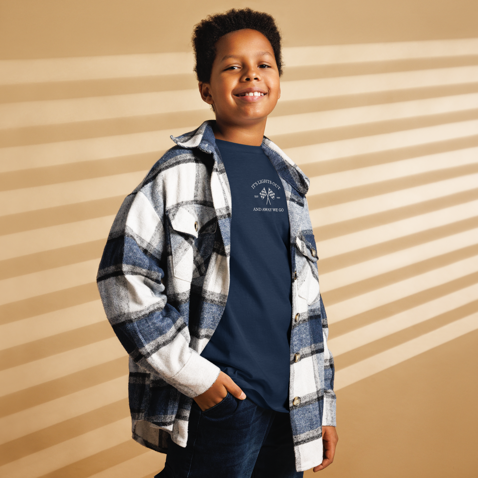 Kids racing t-shirt featuring “It’s Lights Out and Away We Go” with checkered flags. Soft cotton youth motorsport tee for young race fans.